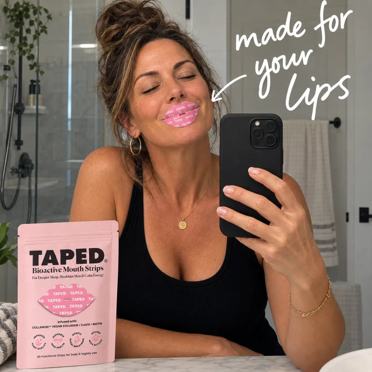 Bathroom mirror selfie showing the TAPED lip-shaped strip and pink pouch